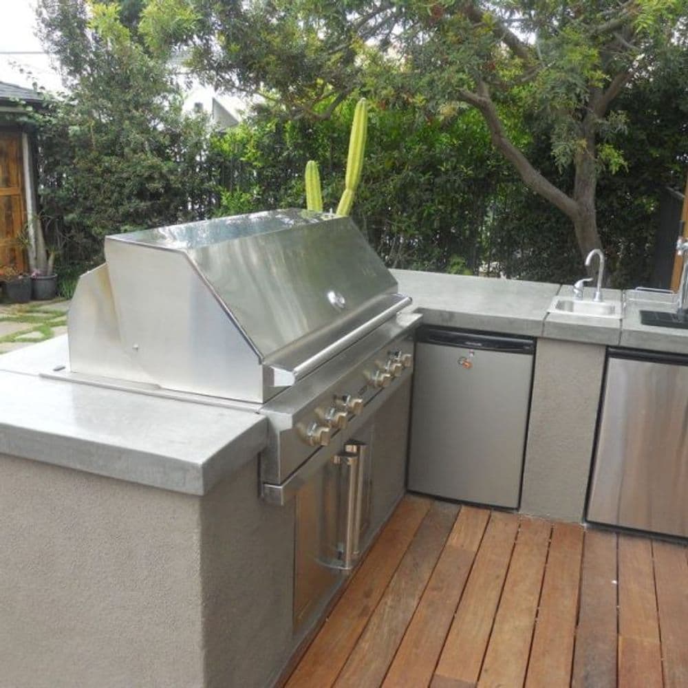 Modern outdoor kitchen featuring a stainless steel grill and sleek countertops.