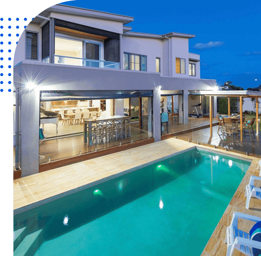 Modern home exterior with pool at dusk, showcasing outdoor living space and elegant design.